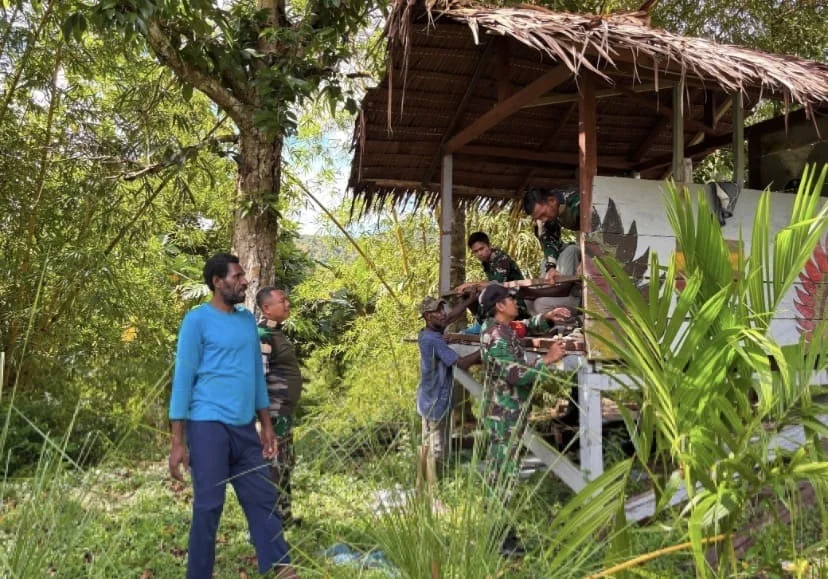 Perkuat Keamanan Lingkungan, Satgas Yonif 511/DY Bersama Warga Benahi Pos Kamling